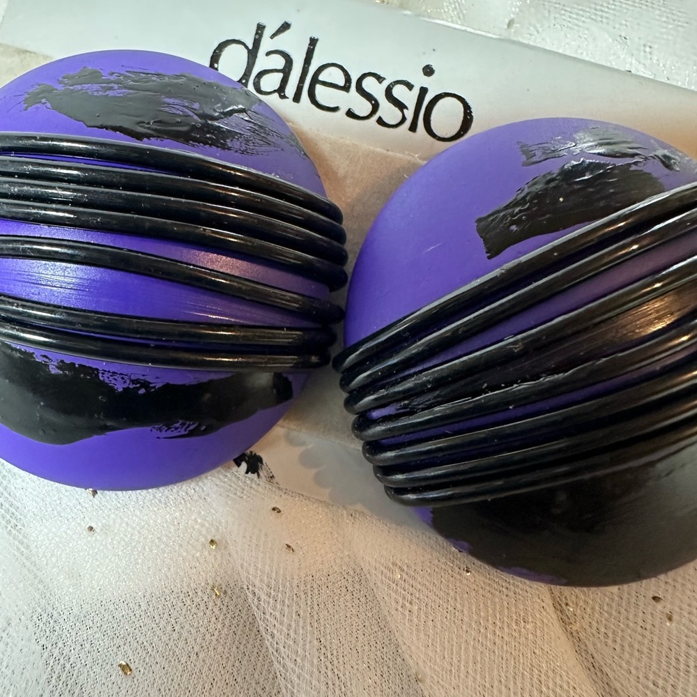 This is a pair of vintage ribbed purple clip-on earrings by d'alessio